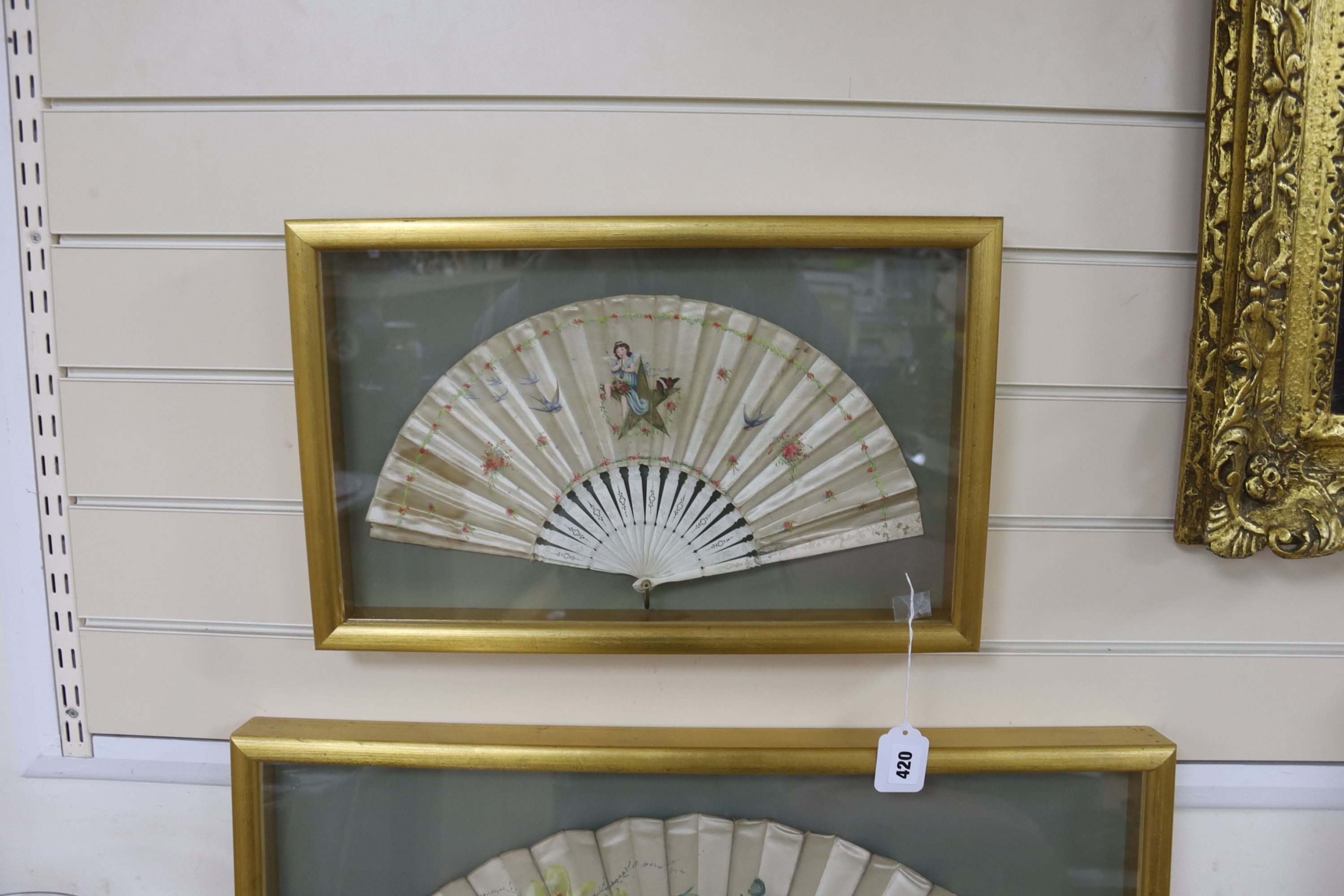 An early 19th century had tinted paper and ebony fan and two late 19th century ivory silk and bone fans, one painted with floral sprays, all three cased, largest case 46 x 71 cm (3)